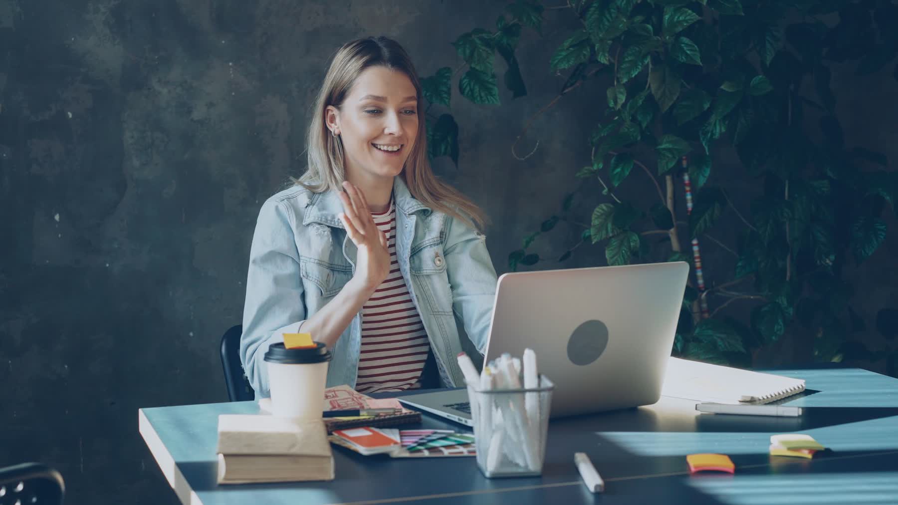Mulher sorrindo durante uma videochamada no trabalho